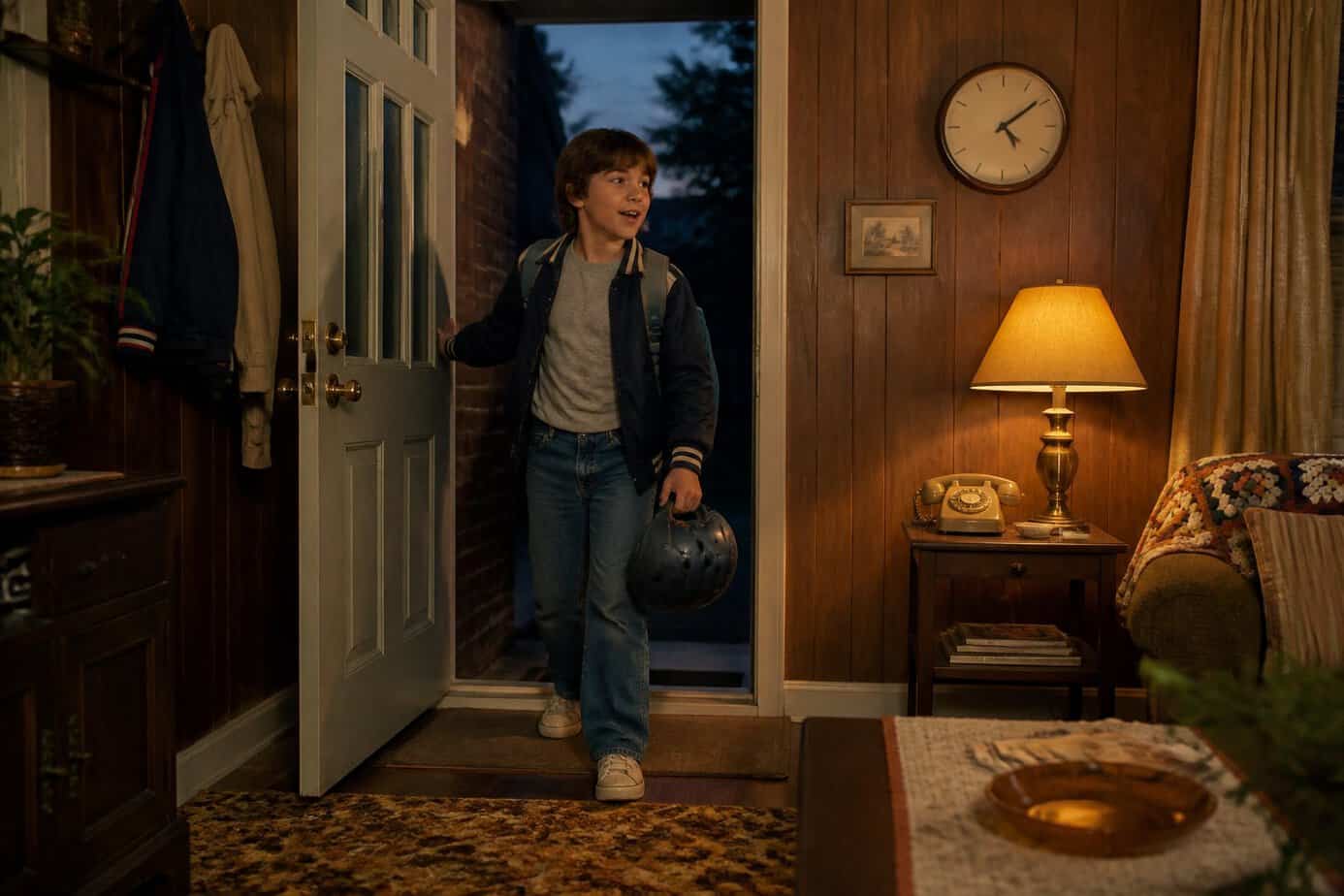 A child arrives home through the front door at evening curfew.
