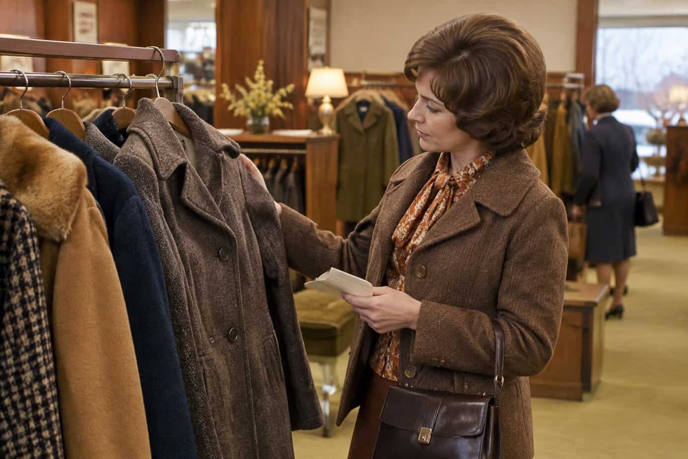 Woman checking winter coats on a sale rack