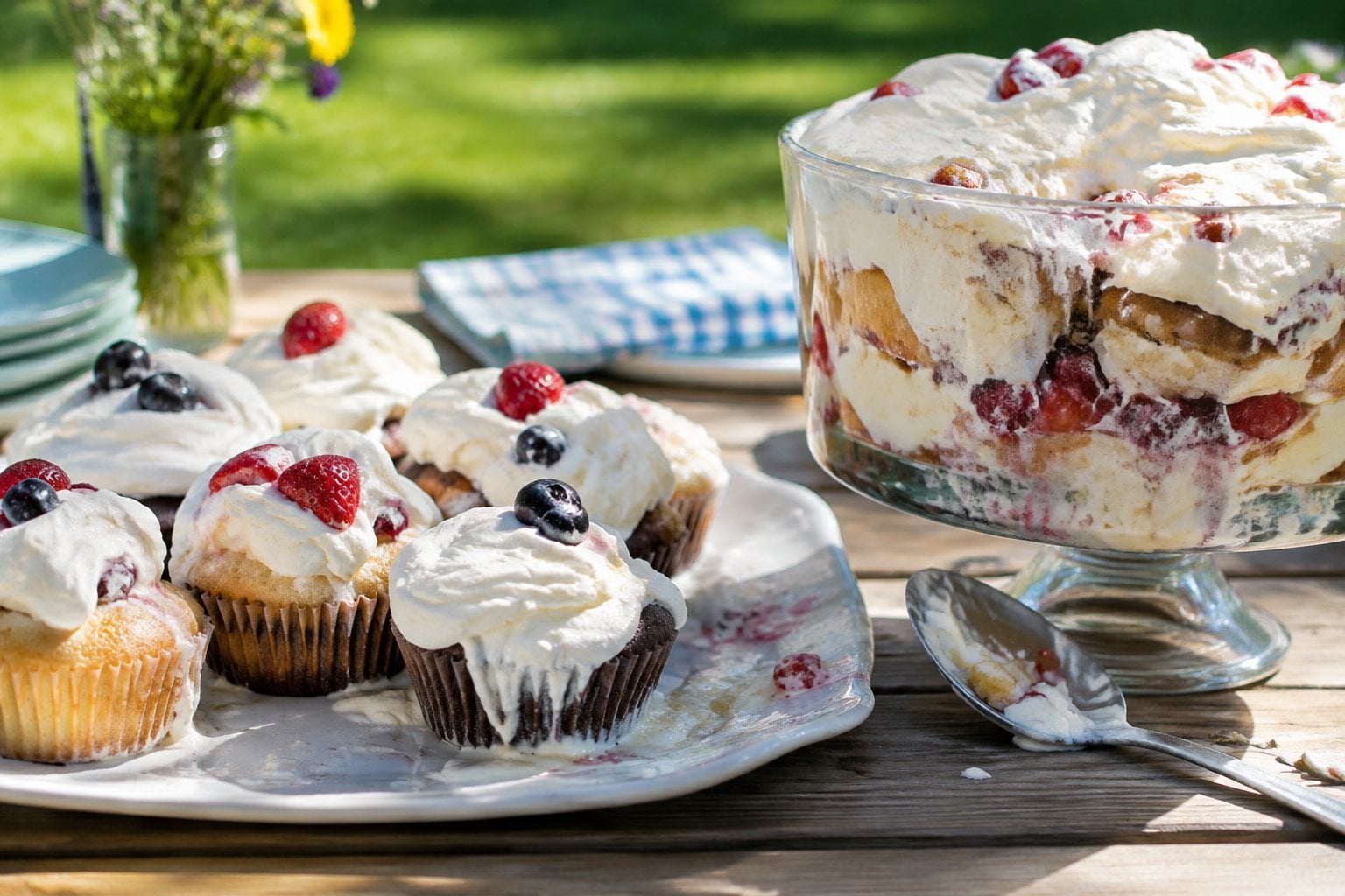 Whipped-cream desserts softening on a picnic table in the sun.