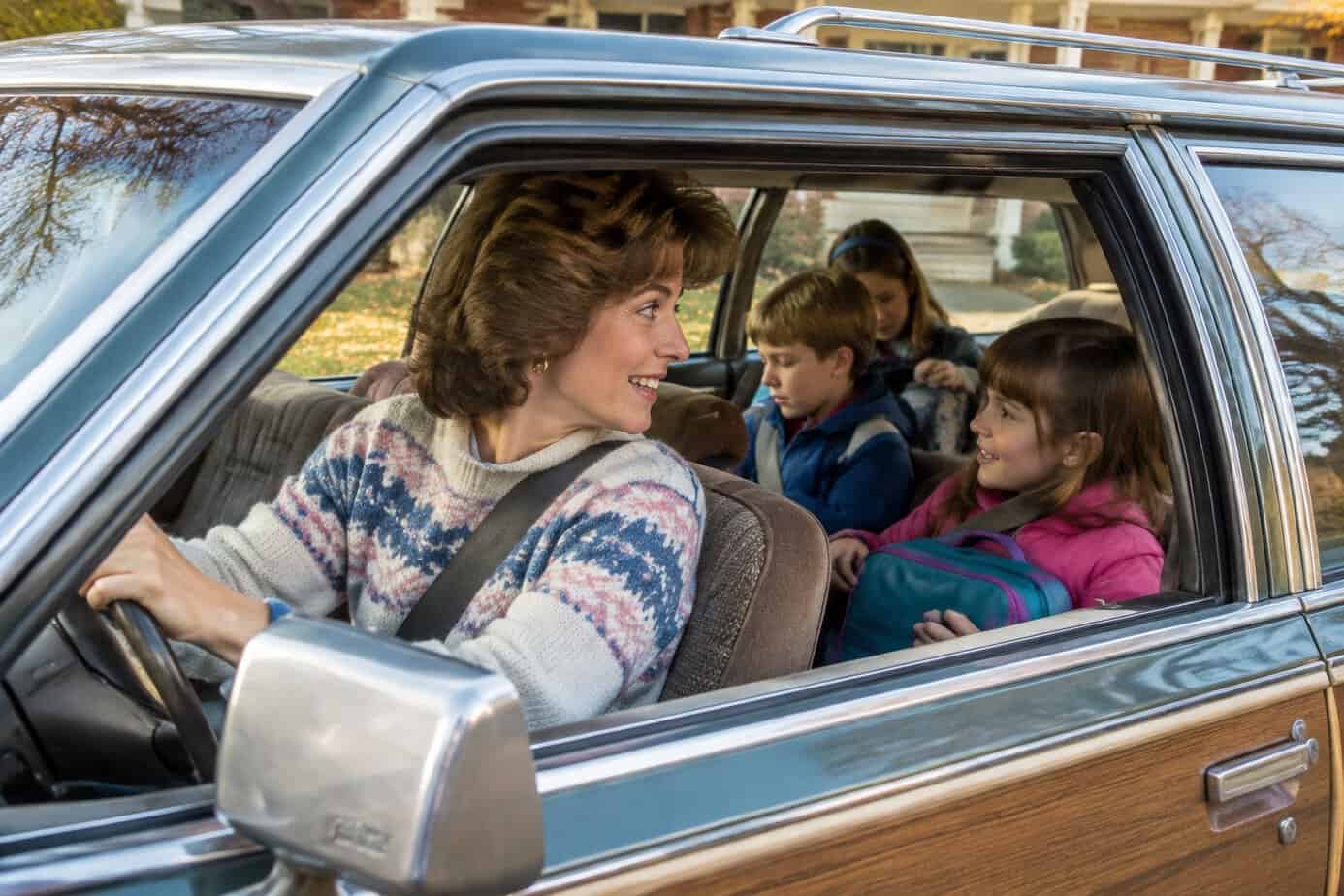 A 1980s mother driving a station wagon full of children