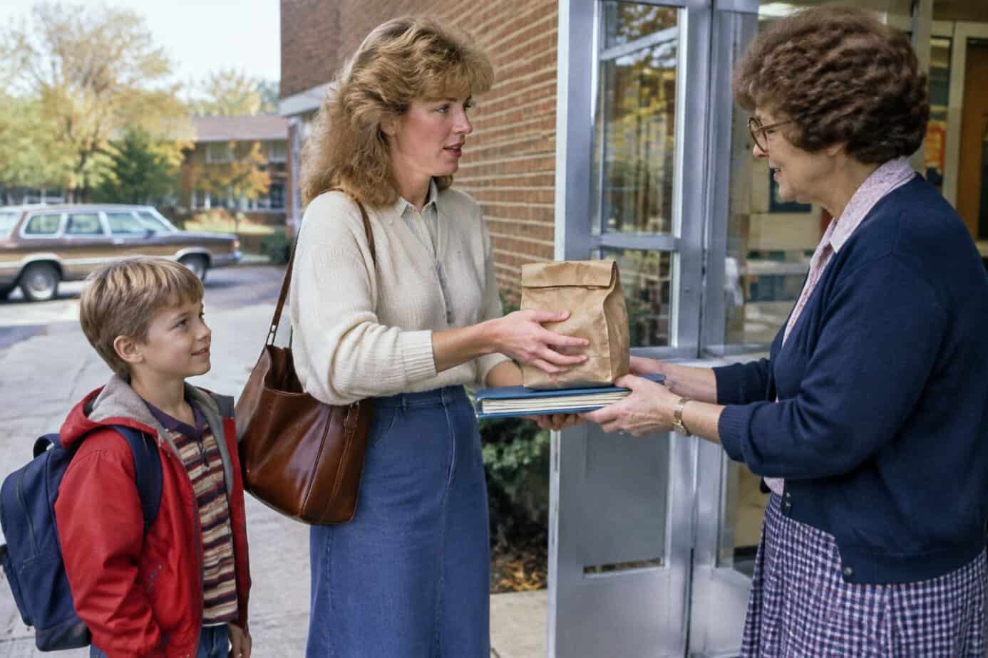 A 1980s mother handing a forgotten lunch to the school office